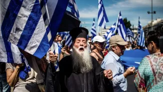 Grèce: faible mobilisation pour une 1ère manifestation contre l'accord avec Skopje Un pope orthodoxe participe à une manifestation à Athènes contre l'accord conclu avec Skopje pour le partage du nom de Macédoine, le 15 juin 2018