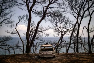 Grèce : Tsípras enfin sur les lieux du désastre, l’opposition monte au créneau Les restes d'une voiture en bord de mer près du village de Mati, le 28 juillet 2018, quatre jours après l'incendie qui a fait au moins 91 morts. Le Premier ministre grec Alexis Tsipras a effectué lundi sa première visite sur les lieux, alimentant de nouveau les critiques de l'opposition qui a réclamé la démission des responsables de ce drame.