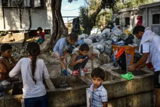 En Grèce, les employés du camp migratoire de Lesbos en grève pour dénoncer la surpopulation Des migrants à l'extérieur du camp migratoire de Moria, sur l'île de Lesbos, en Grèce, le 5 août.