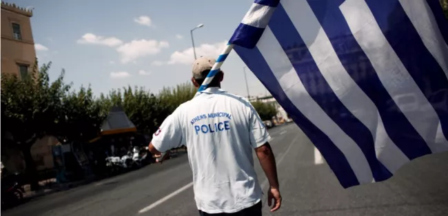 Un membre de la police municipale manifeste devant le Parlement grec, le 15 juillet 2013 à Athènes. (ANGELOS TZORTZINIS/AFP)


