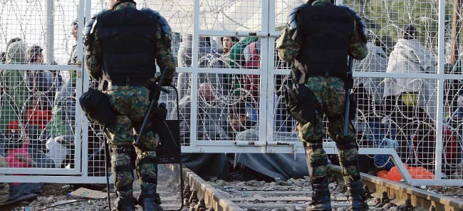 Depuis le début de la semaine, les policiers macédoniens gardent la frontière fermée sur la voie qui relie la Macédoine à la Grèce. Crédits photo : MARKO DJURICA/REUTERS


