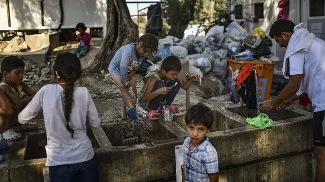 Des migrants se lavent dans un camp sur l'île de Lesbos, en août 2018.


