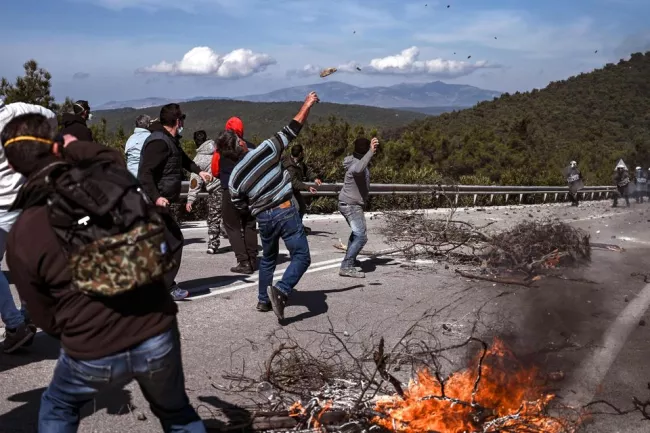 Des manifestants opposés à la construction d'un nouveau camp de migrants près de la ville de Mantamados, sur l'île de Lesbos, affrontent la police anti-émeute mercredi.


