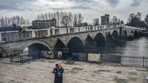 Une femme migrante et son enfant sur le quai de la rivière Toundja, près de Pazarkule dans le nord-ouest de la Turquie, le 5 mars 2020.


