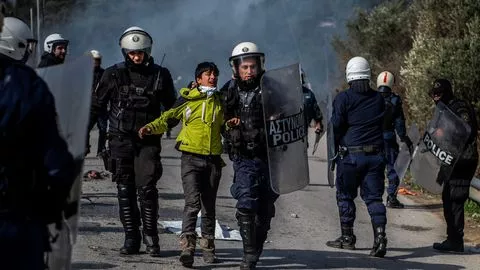 Un jeune migrant emporté par la police après des heurts survenus près du camp de réfugiés à Lesbos en Grèce le 2 mars.



