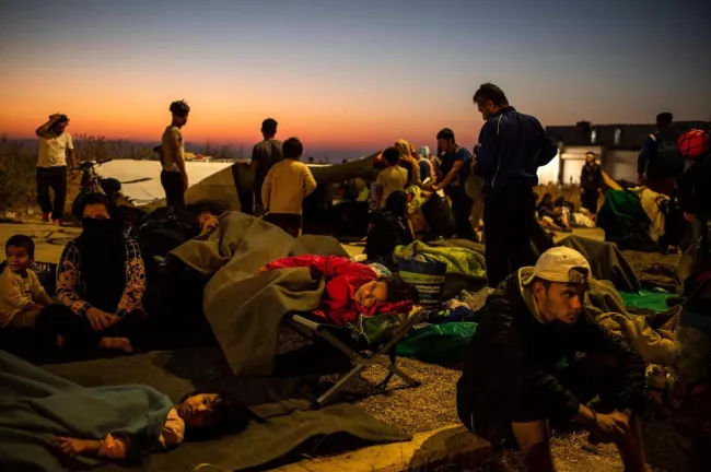Des exilés passent la nuit dans la rue après l'incendie du camp de la Moria, ce vendredi.


