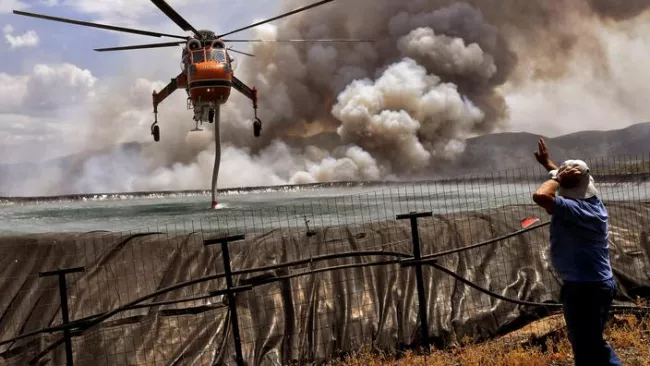 Un hélicoptère pompe de l'eau dans un réservoir à proximité de Corinthe pour lutter contre l'un des nombreux incendies qui touchent la Grèce cet été. VASSILIS PSOMAS / REUTERS


