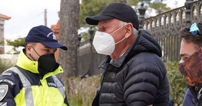Un policier grec escorte le photographe norvégien Knut Bry au tribunal de Lesbos, en Grèce, le 18 mars.


