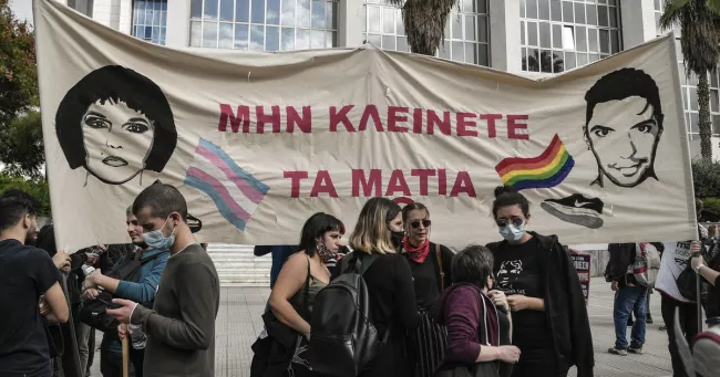 Des militants tiennent une banderole sur laquelle on peut lire «Ne fermez pas les yeux» près d'un tribunal à Athènes, le 21 octobre 2020, au début du procès concernant la mort de Zak (Zackie) Kostopoulos. — © LOUISA GOULIAMAKI / AFP


