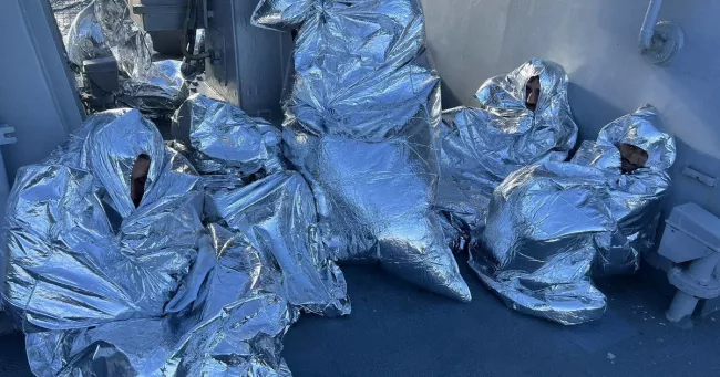 Des migrants, recouverts de couvertures isothermes d'urgence, ont été secourus près du cap Kafireas, sur l'île d'Evia, en Grèce, le 1er novembre 2022. — © HELLENIC COAST GUARD / VIA REUTERS


