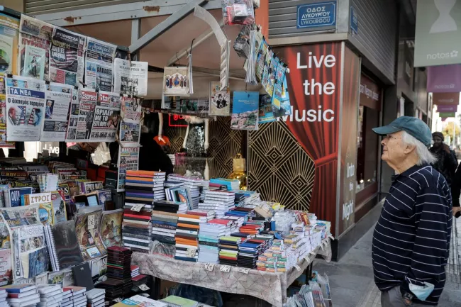 Un homme lit les titres des journaux sur les élections américaines dans un kiosque à journaux à Athènes, Grèce, le 6 novembre 2024. LOUISA GOULIAMAKI / REUTERS