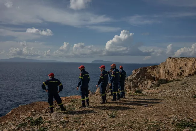 Des pompiers envoyés en renfort sur l'île d'Amorgos regardent au loin l'île d'Anydros, considérée comme l'épicentre de l'essaim de tremblements de terre, sur l'île grecque d'Amorgos, dans la mer Egée, le 15 février 2025. ANGELOS TZORTZINIS / AFP