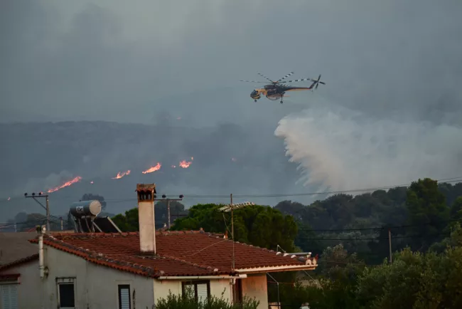 Un hélicoptère Sikorsky S-64 Skycrane largue de l'eau sur un incendie de forêt à Palaia Fokaia, à environ 45 kilomètres au sud d'Athènes.
