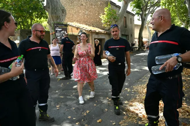 Une femme remercie les pompiers pour leur lutte contre les incendies à Tournissan, dans le sud de la France, le 10 août 2025  -  Bertrand GUAY - Tournissan (AFP)