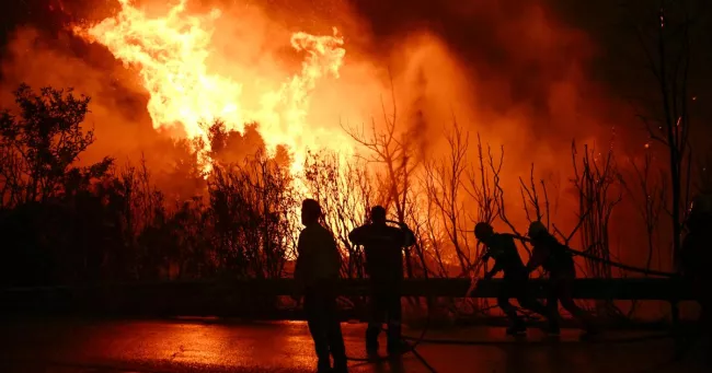 Des pompiers grecs luttant contre les flammes dans les environs de la ville de Patras, le 13 août 2025. PHOTO ARIS MESSINIS/AFP