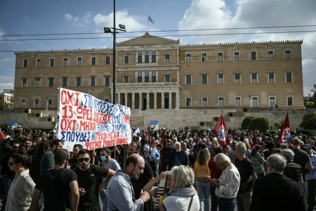 Des manifestants sont regroupés devant le Parlement grec lors d'une grève contre une réforme permettant des journées de travail de 13 heures, le 14 octobre 2025 à Athènes  -  Aris MESSINIS - Athènes (AFP)
