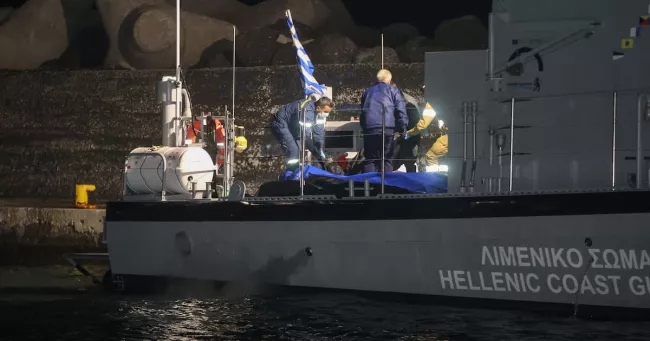 Des garde-côtes transportent les corps des victimes, dans la nuit de samedi à dimanche, en Crète. 