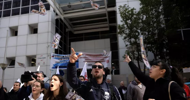 Des marins grecs lancent de faux billets de dollars en l'air lors d'une manifestation devant le siège de l'Union des armateurs grecs. Louiza Vradi / REUTERS