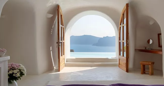 Piscine à débordement et suites troglodytes plongent dans la caldeira de Santorin : un balcon suspendu au‑dessus de la mer Égée, taillé pour les escapades à deux. Photo presse