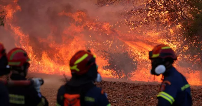 Des pompiers luttent contre le feu près du village d'Agia Paraskevi, au nord-est d'Athènes, le 2 août 2026.