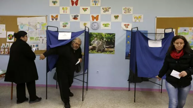 Traditionnellement, les bureaux de vote se remplissent l'après-midi, et dans la matinée ils étaient peu nombreux à prendre le chemin des urnes dans la capitale grecque. Crédits photo : Thanassis Stavrakis/AP


