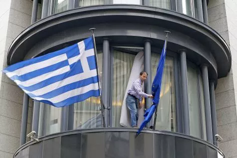 © Yves Herman - Photo d'illustraion: Un homme ajuste le drapeau européen , à côté du drapeau grec, sur la façade de l'ambassade du pays à Bruxelles.


