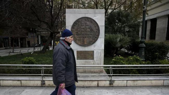Un homme passe devant une réplique de pièce de drachme, à Athènes. Crédits photo : ALKIS KONSTANTINIDIS/REUTERS



