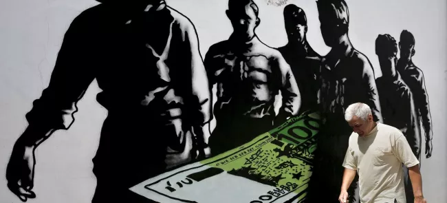 Dans une rue d'Athènes, un homme passe devant un graffiti intitulé «La mort des euros». Crédits photo : © Alkis Konstantinidis / Reuter/REUTERS


