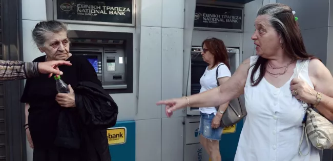 Devant un distributeur de la Banque nationale de Grèce, le 29 juin à Athènes. (AFP PHOTO / LOUISA GOULIAMAKI)


