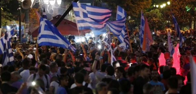 La fête bat son plein pour les supporters du non à la nuit tombante, après les premiers résultats du référendum, place Syntagma à Athènes le 5 juillet. (AP Photo/Emilio Morenatti)


