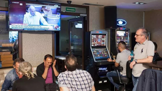 Au Café Exodos, à Berlin, le patron Nikos Lampadaviou regarde à la télévision Yanis Varoufakis, alors ministre des Finances grec.


