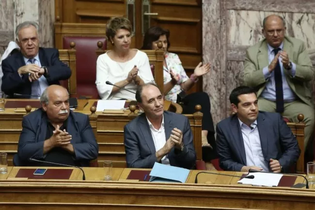 Des membres du gouvernement grec dont le ministre des Finances Euclid Tsakalotos (C), et le Premier ministre Alexis Tsipras (D), lors d'un débat au Parlement, le 14 août 2015 à Athènes (Photo Panayiotis Tzamaros. AFP)


