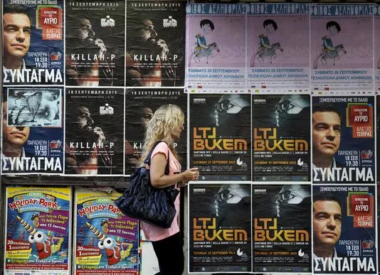 Une femme passe devant des affiches, dont celles de Syriza, le 18 septembre à Athènes, en Grèce.


