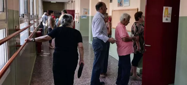 Des Grecs lors des élections de ce dimanche Crédits photo : LOUISA GOULIAMAKI/AFP


