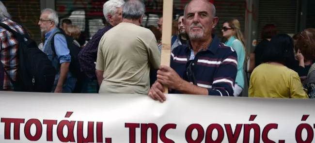 Des manifestants protestent devant  le ministère du travail, mercredi à Athènes,  alors que le parlement  a voté l'abaissement des pensions de retraite. Crédits photo : LOUISA GOULIAMAKI/AFP


