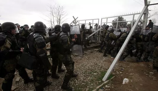 Des migrants tentent de forcer la barrière qui sépare la Grèce de la Macédoine, le 29 février.


