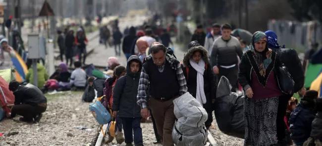 Des réfugiés longent la voie ferrée, près du village d'Idomeni jeudi, dans l'espoir de passer la frontière. Crédits photo : SAKIS MITROLIDIS/AFP


