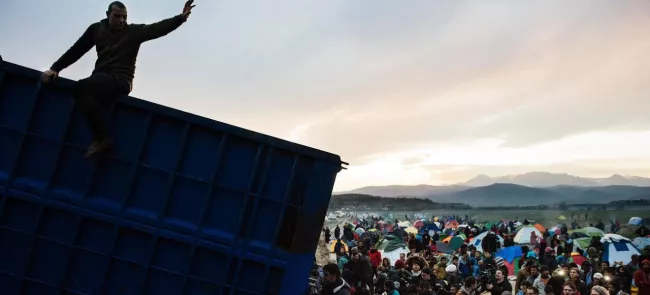 Des migrants se précipitent pour récupérer du bois de chauffage dans le camp d'Idomeni en Grèce, près de la frontière avec la Macédoine, le 6 mars. Crédits photo : DIMITAR DILKOFF/AFP


