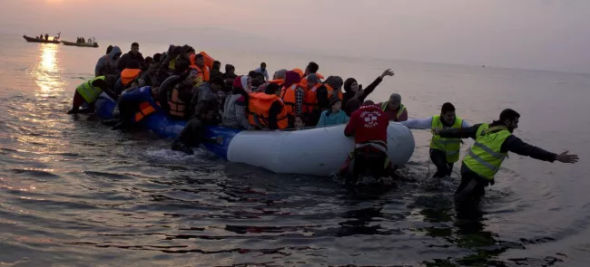 Des migrants en provenance de Turquie par la mer Égée accostent, dimanche,  sur le rivage de l'île grecque de Lesbos. Crédits photo : Petros Giannakouris/AP


