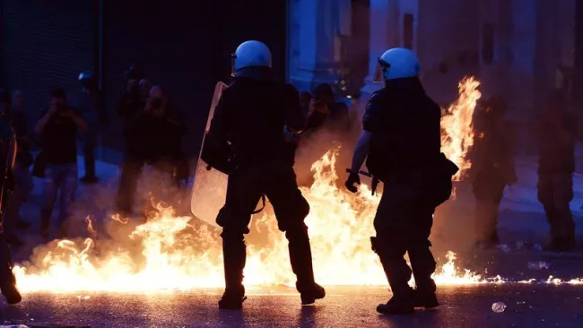 La police grecque a dû faire face à des manifestations violentes dimanche à Athènes Crédits photo : LOUISA GOULIAMAKI/AFP



