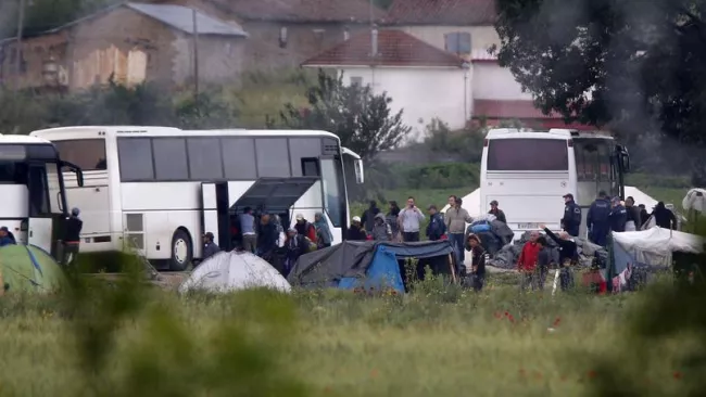 Des migrants quittent le camp d'Idomeni à bord de bus, ce mardi. Crédits photo : Boris Grdanoski/AP


