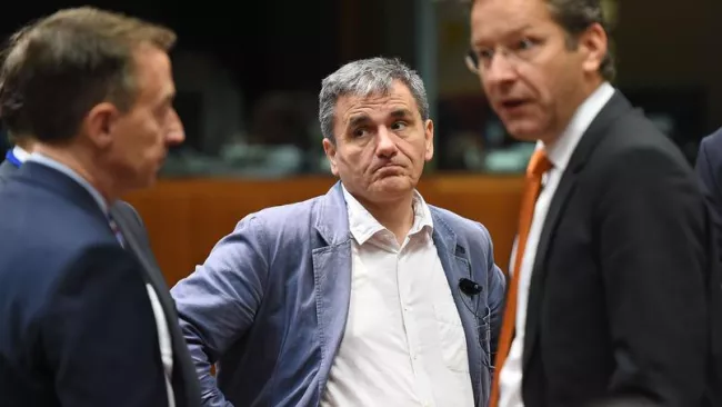 Le ministre grec des Finances Euclide Tsakalotos, au centre, et son homologue néerlandais, président de l'Eurogroupe, Jeroen Dijsselbloem, à droite, mercredi matin à Bruxelles. Crédits photo : EMMANUEL DUNAND/AFP


