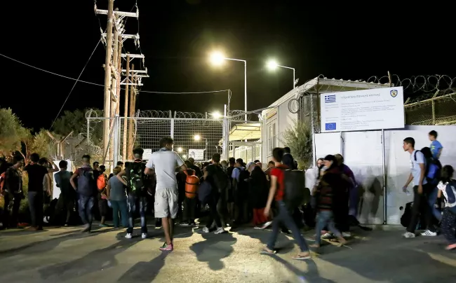 Des migrants devant les portes fermées du camp de Moria, ce lundi. Crédits photo : INTIME/REUTERS


