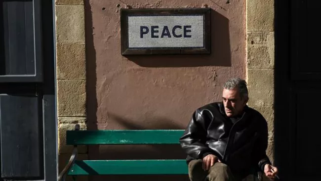 Un homme assis sur un banc à Nicosie.



