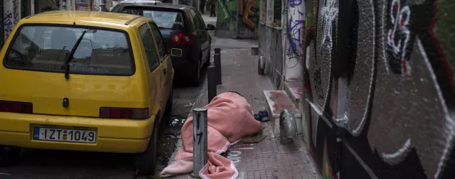 Un sans-abri dort dans une rue d'Athènes. © ANGELOS TZORTZINIS / AFP


