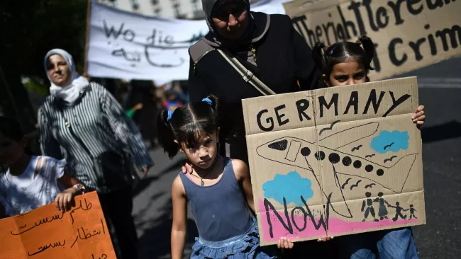 Des réfugiés manifestent au centre d'Athènes devant l'ambassade d'Allemagne accusant Berlin d'entraver le regroupement familial, le 2 août 2017. afp.com/ARIS MESSINIS



