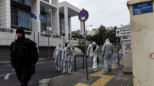 Des enquêteurs de la police grecque recherchent des indices après l'explosion d'un engin devant la cour d'appel d'Athènes, le 22 décembre 2017


