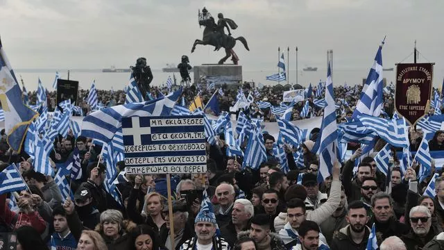Des opposants au maintien du mot "Macédoine" dans le futur nom du pays brandissent des drapeaux de la Grèce, devant la statue d'Alexandre le Grand, le 21 janvier 2018 lors d'une manifestation à Thessalonique


