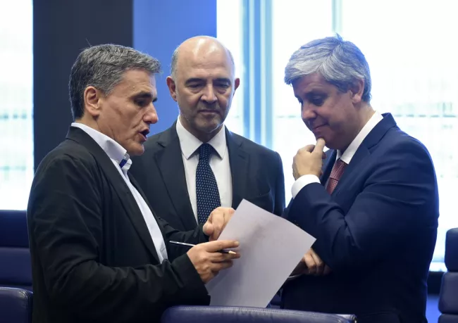 Les Européens ont débattu une partie de la nuit sur les paramètres de la dette grecque. Ici, le ministre grec des Finances, Euclide Tsakalotos et le président de l'Eurogroupe, Mario Centeno, entourent le commissaire aux Affaires économiques, Pierre Moscovici. - John Thys/AFP


