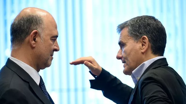 Le commissaire européen aux Affaires financières Pierre Moscovici (g) et le ministre grec des Finances Euclid Tsakalotos lors d'une réunion de l'eurogroupe à Luxembourg, le 21 juin 2018



